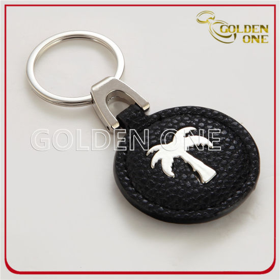 Ovaler Schlüsselanhänger aus Metall und Leder mit Antikgoldprägung