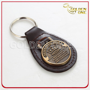 Ovaler Schlüsselanhänger aus Metall und Leder mit Antikgoldprägung